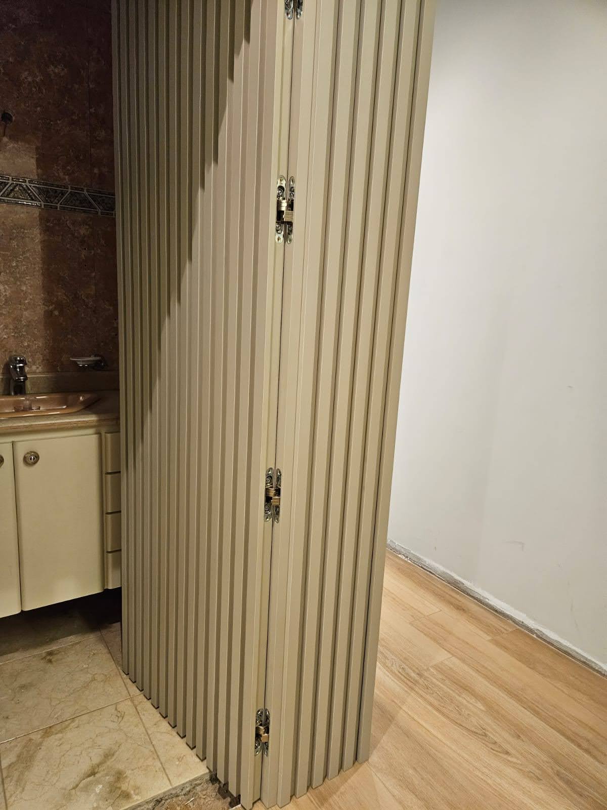Exemplo de porta mimetizada embutida no painel de MDF na sala