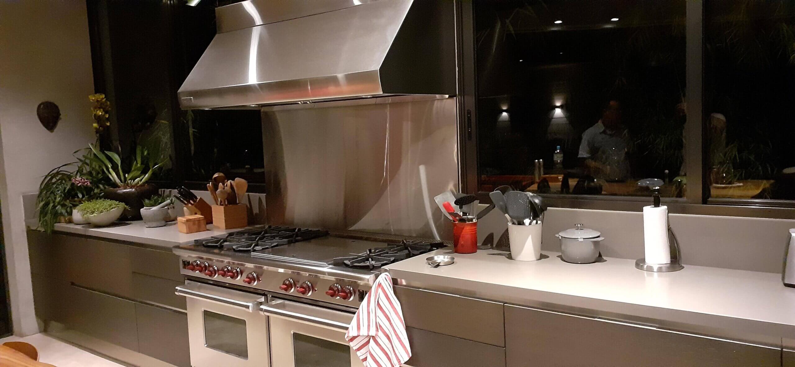 Cozinha Cinza com fogões e coifa industrial