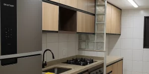 Cozinha planejada pequena com armários sob medida e bancada compacta