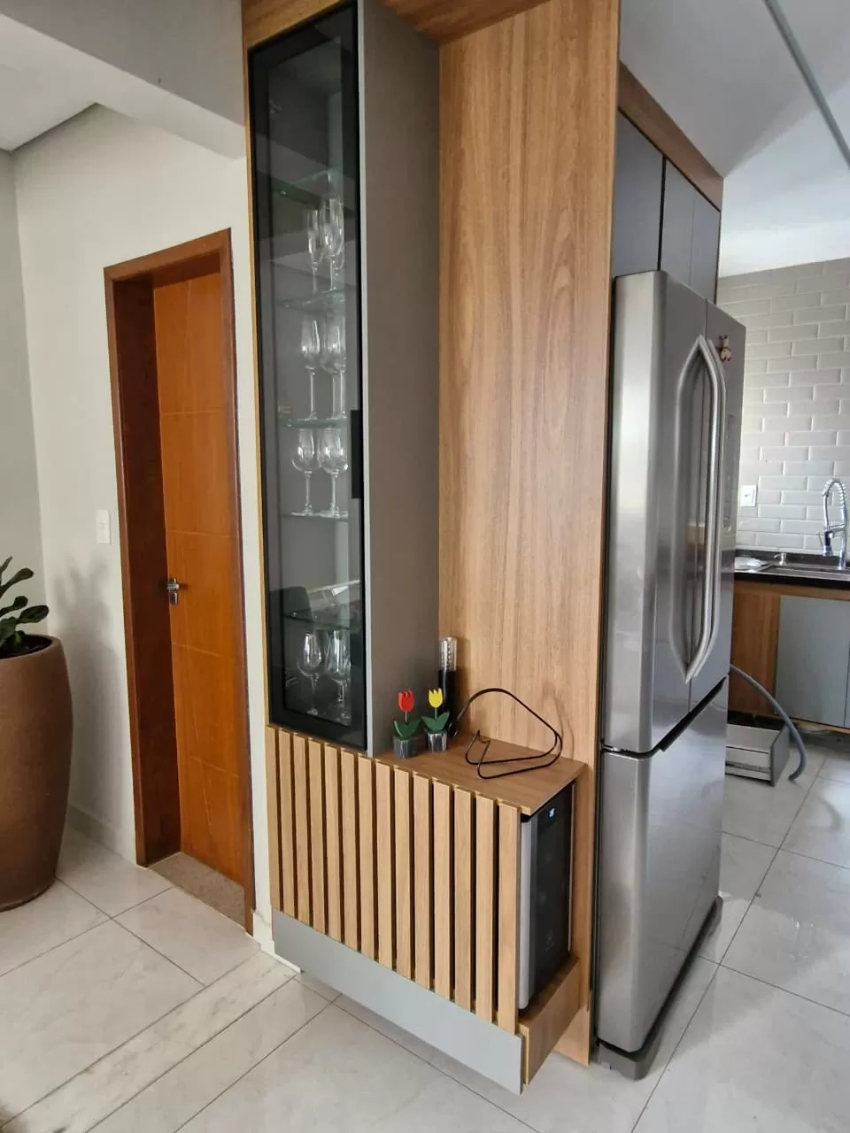 Cristaleira com porta de vidro e iluminação embutida — projeto de cozinha planejada em Conselheiro Lafaiete
