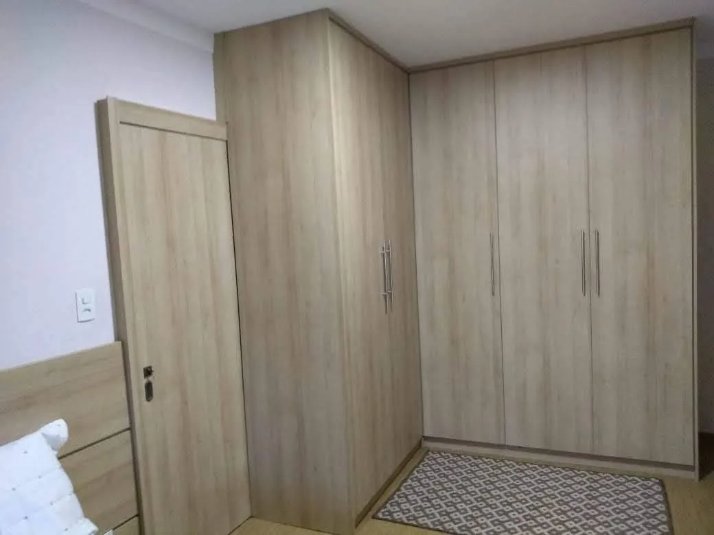 Quarto de casal planejado em MDF Riviera Duratex com cabideiros extensíveis e puxadores tubulares, executado pela Amazonas Planejados em Conselheiro Lafaiete