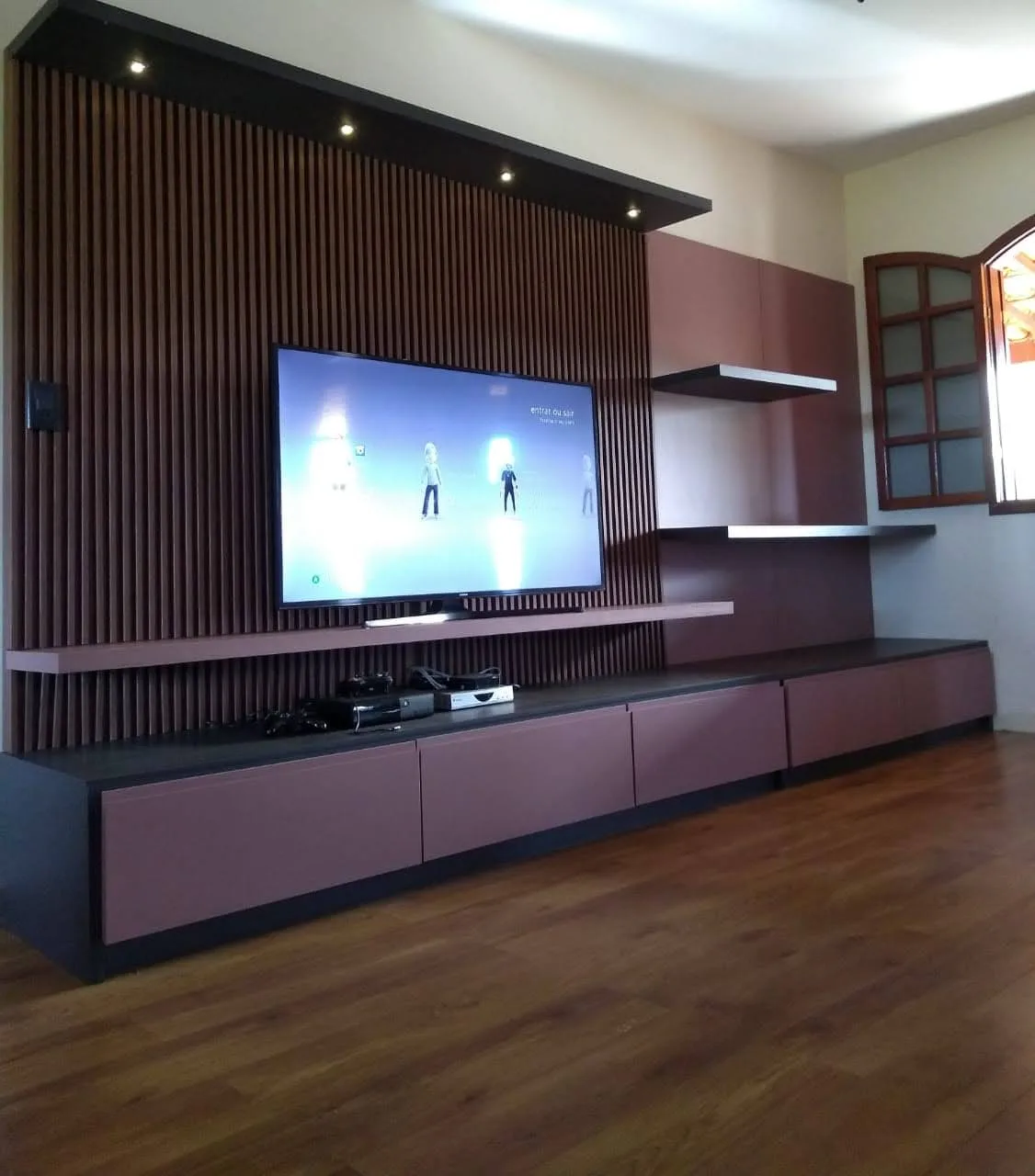 Sala de TV planejada com painel ripado em MDF Preto Trama e Rosa Glamour Duratex, executada pela Amazonas Planejados em Carandaí MG