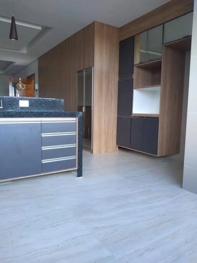 Cozinha planejada em MDF Grafite e Carvalho Hanover com painel que oculta caixa da escada convertida em despensa, executada pela Amazonas Planejados em Conselheiro Lafaiete