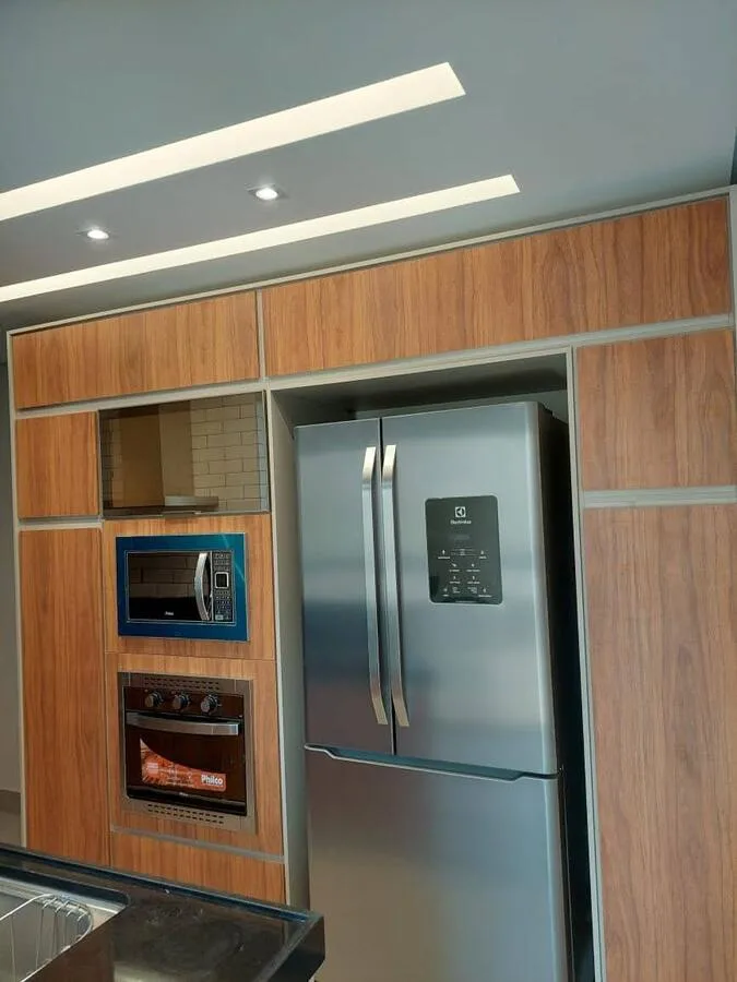 Cozinha planejada paralela em MDF Gianduia e Cumarú com puxadores cava e torre quente, Bairro Quinta das Flores, Conselheiro Lafaiete, executada pela Amazonas Planejados